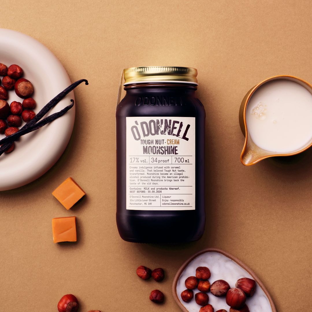 Tough Nut cream jar on a brown surface surrounded by ingredients