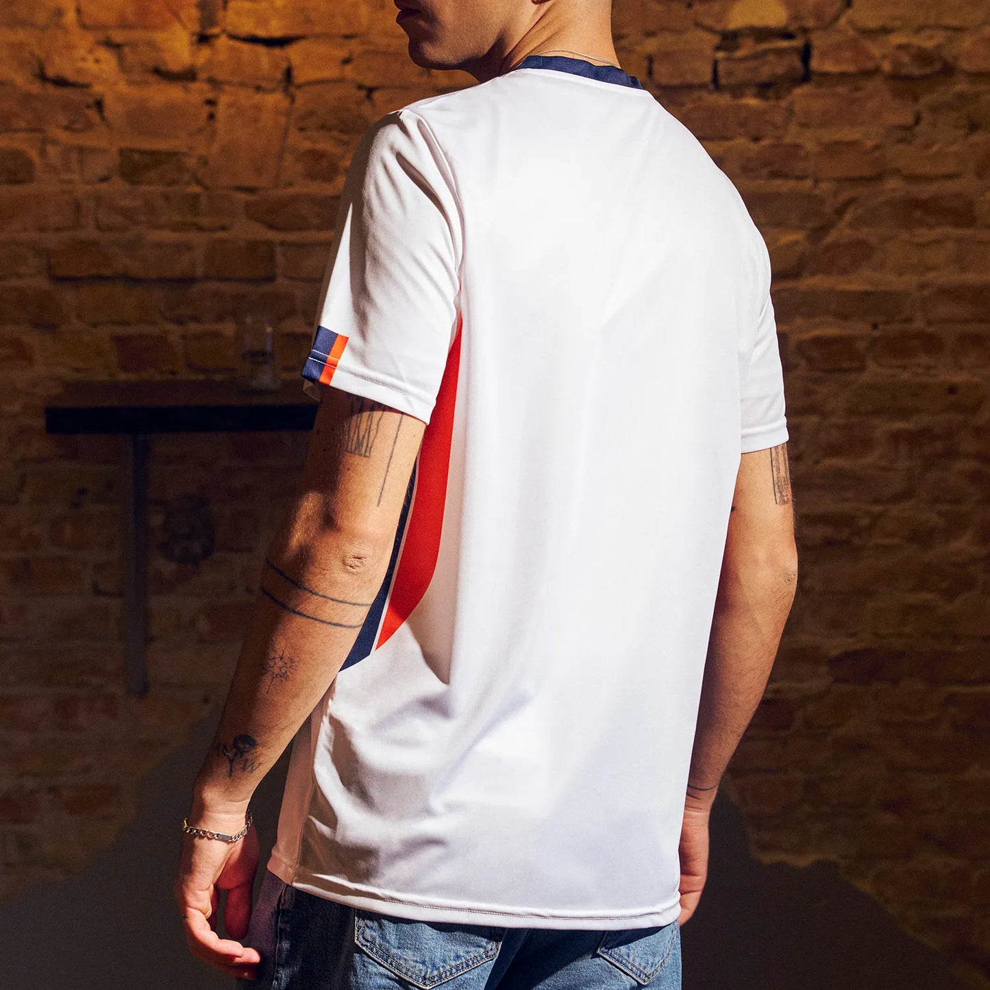 O'Donnell Moonshine WM Football Jersey – model wearing white jersey with navy and orange side stripes, back view