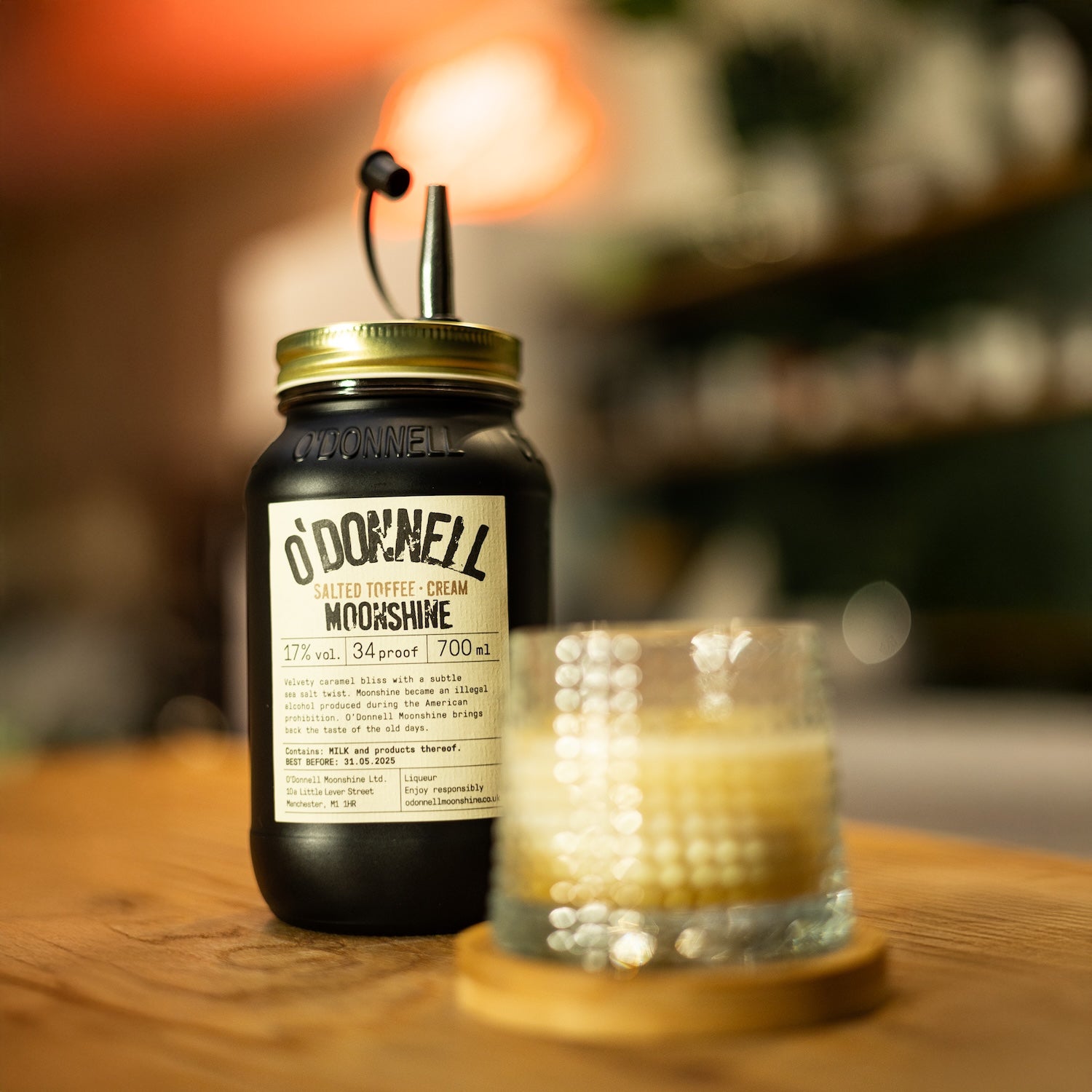 700ml Jar of O'Donnell Salted Toffee Cream Moonshine with Pouring lid and a glass of liqueur
