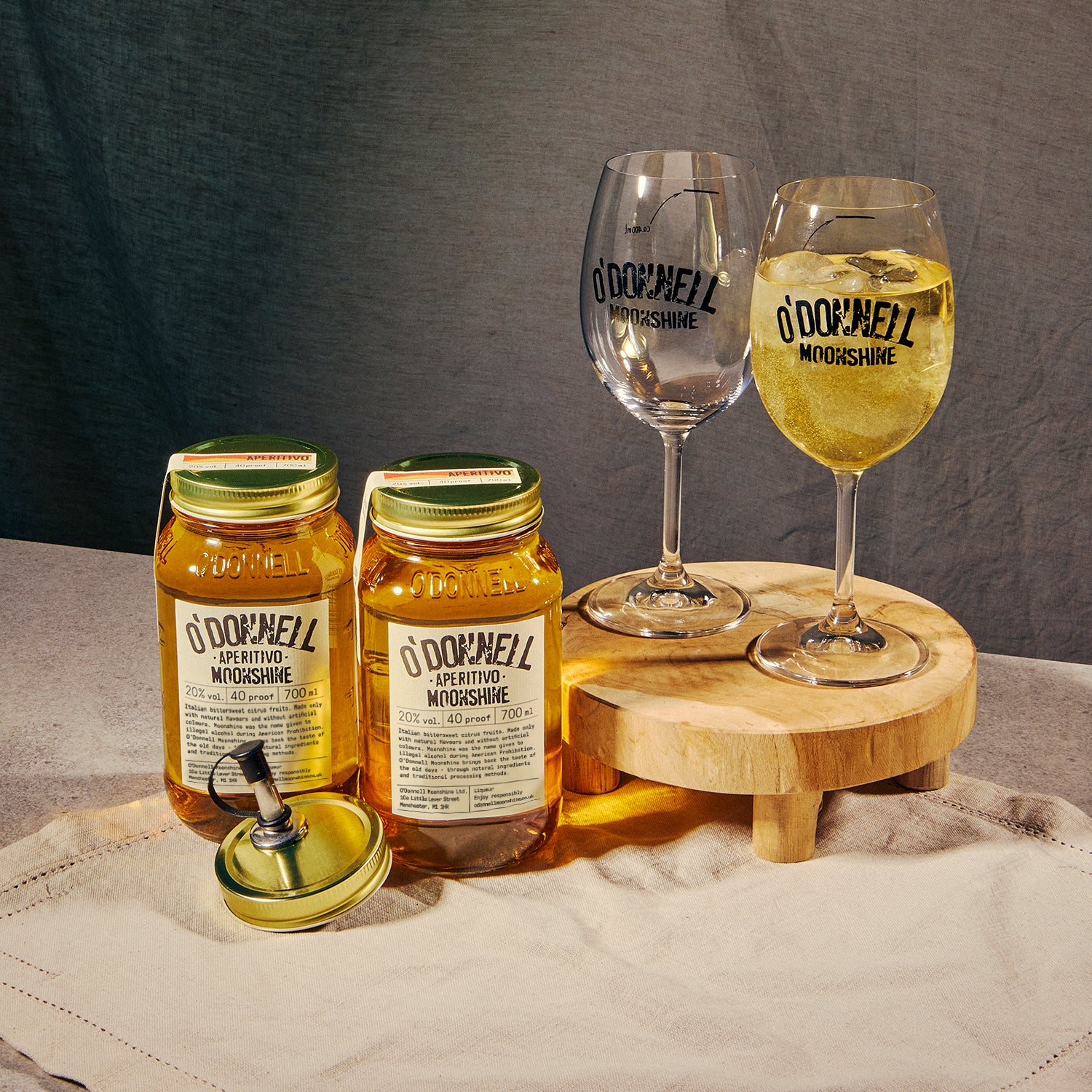 Two O'Donnell Sprit Glasses next to 2 700ml Jars of Aperitivo Moonshine and a pouring lid