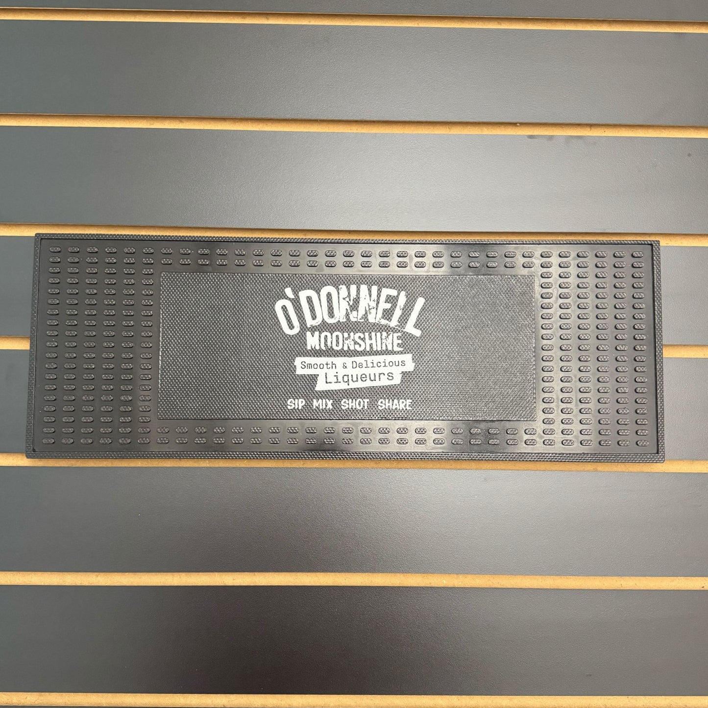 Black bar mat with 'O'Donnell Moonshine' branding on a wooden surface.