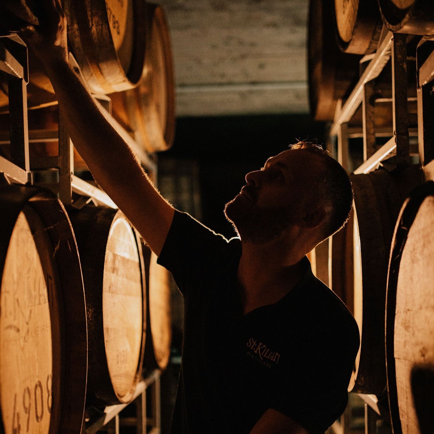 Person in a warehouse with wooden barrels
