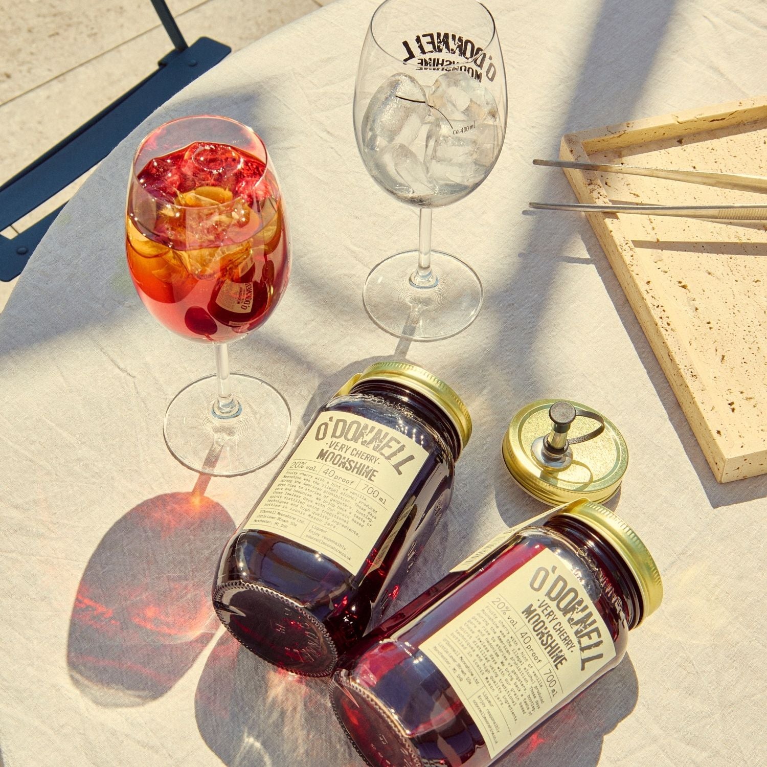 Two O'Donnell Sprit Glasses next to 2 700ml Jars of Very Cherry Moonshine and a pouring lid