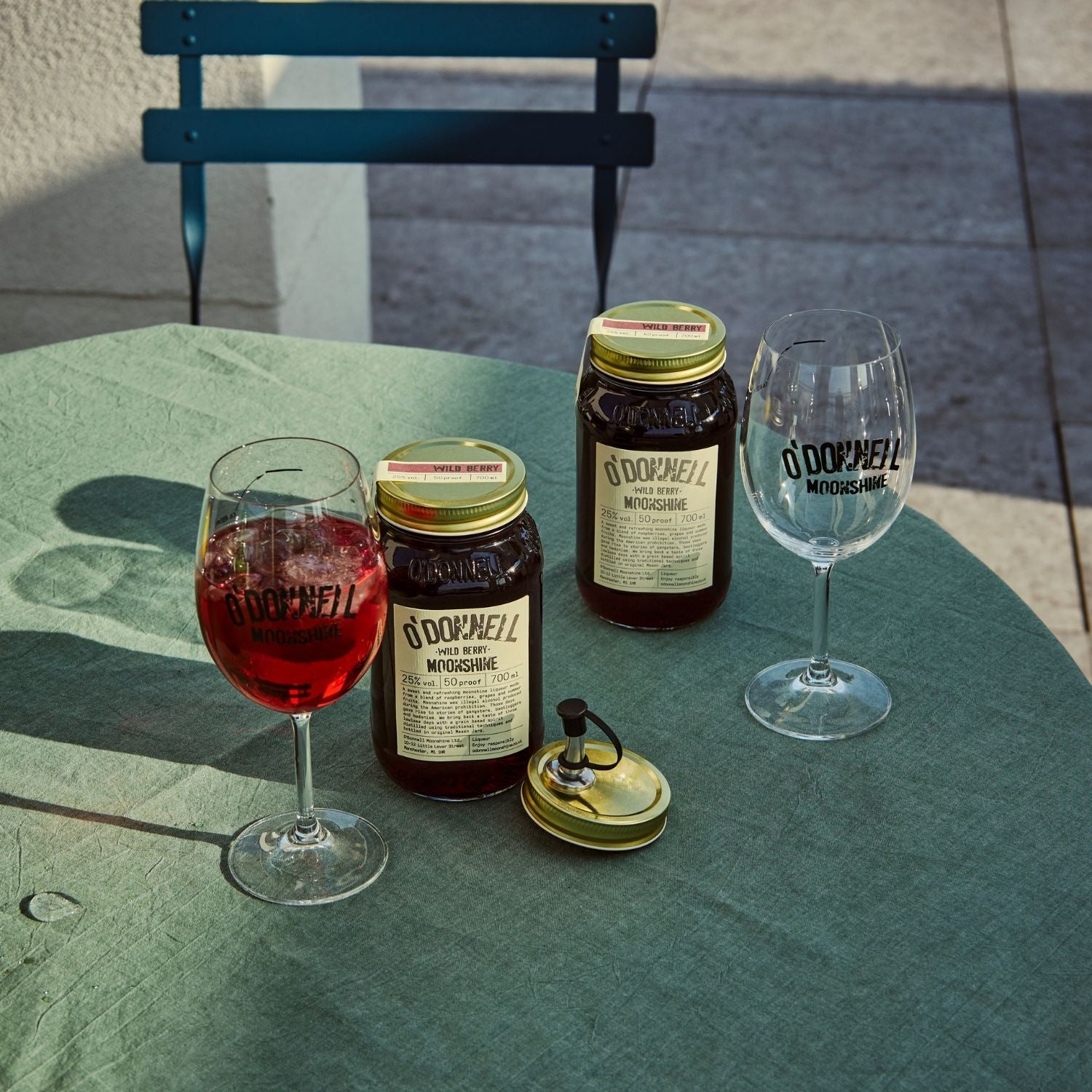 Two O'Donnell Sprit Glasses next to 2 700ml Jars of Wild Berry Moonshine and a pouring lid