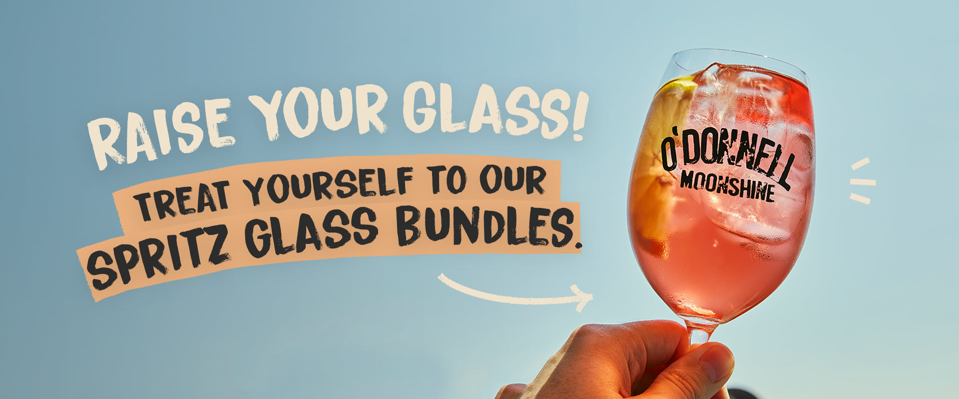 Raise your glass, shop spritz bundles. Image of a Spritz glass filled with a moonshine spritz against a blue background