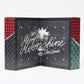 Micro Advent Calendar 2025 on a white background. Open to show text ' Cheers, Merry Moonshine Christmas' with a ripped wrapping paper pattern on the outside