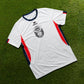 O'Donnell Moonshine WM Football Jersey – white jersey with navy collar and orange side stripes, flat lay on grass
