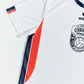 O'Donnell Moonshine WM Football Jersey – angled side view showing orange side stripe and navy trim, Copa badge visible, white background