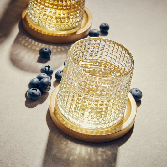 glass tumbler on a wooden coaster
