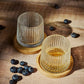 Two textured Tumbler Glasses on a wooden coaster. Surrounded by blueberries