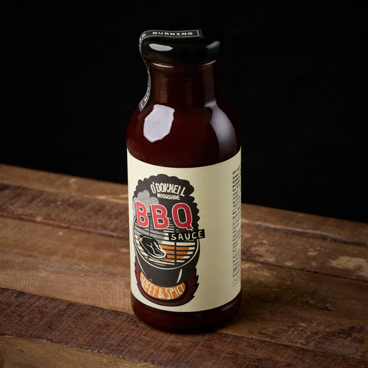 Bottle of BBQ sauce on a wooden surface with a black background