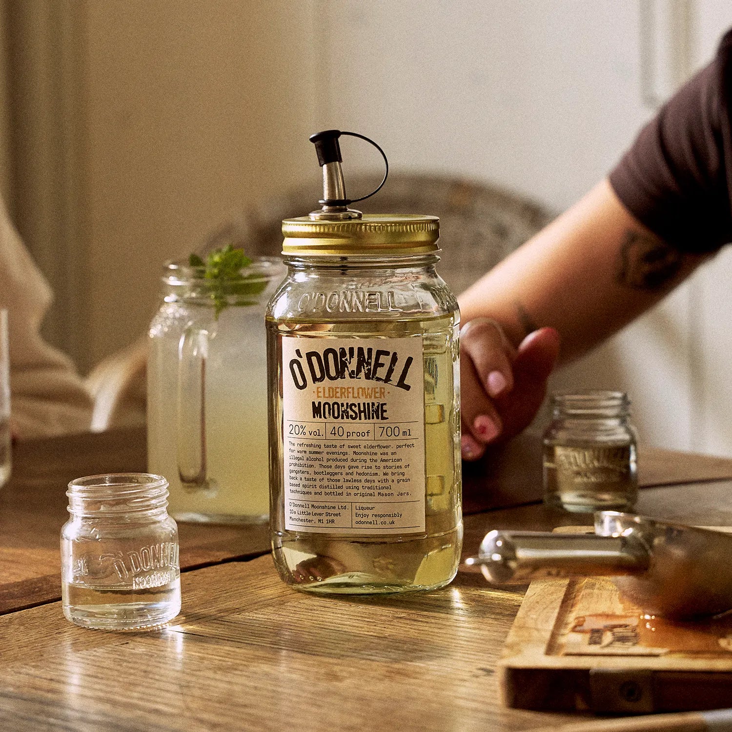 O'Donnell Moonshine elderflower liqueur, with a Mason jar in front of a prepared cocktail.