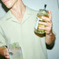 O'Donnell Moonshine Elderflower Liqueur in a Mason jar, with a man in the foreground enjoying it as a cocktail.