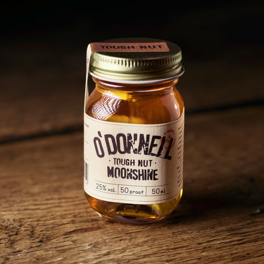 A 50ml mini jar of O'Donnell Moonshine with the label 'Tough Nut' placed on a wooden surface.